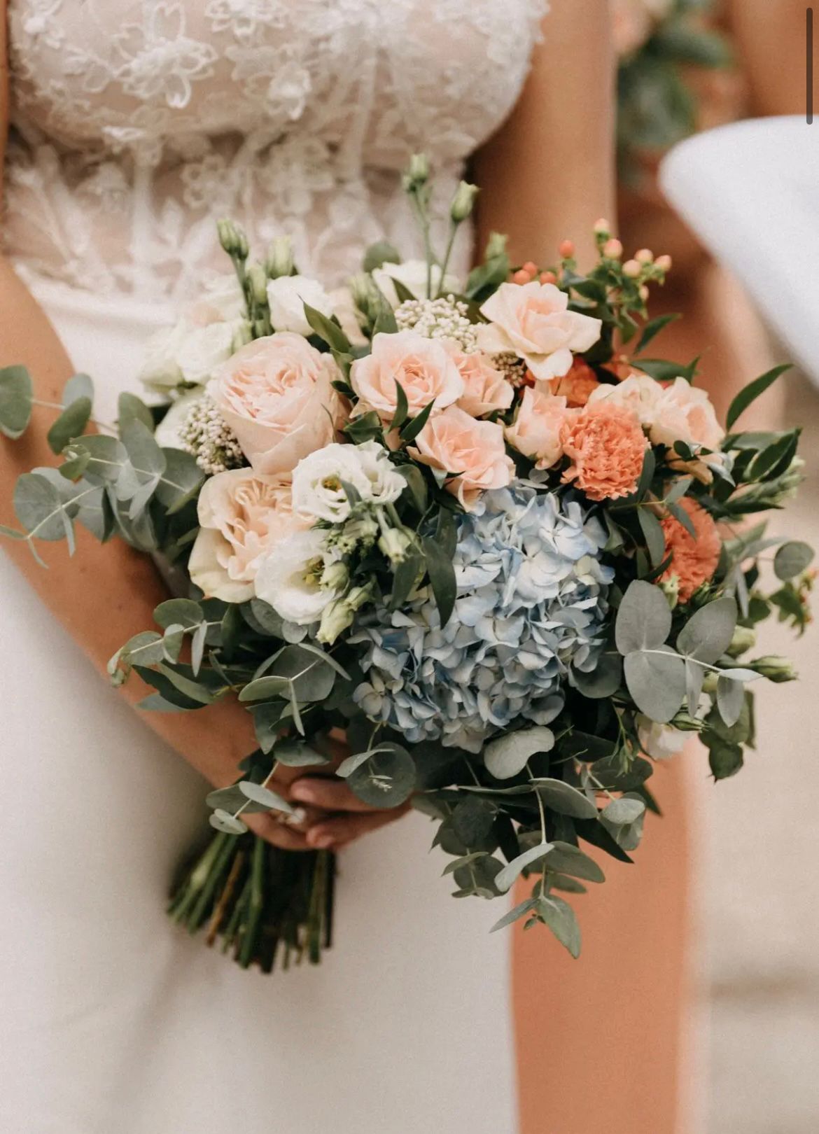 Bouquet LIPPOLIS con ortensie celesti, rose peach e garofani arancio — composizione estiva